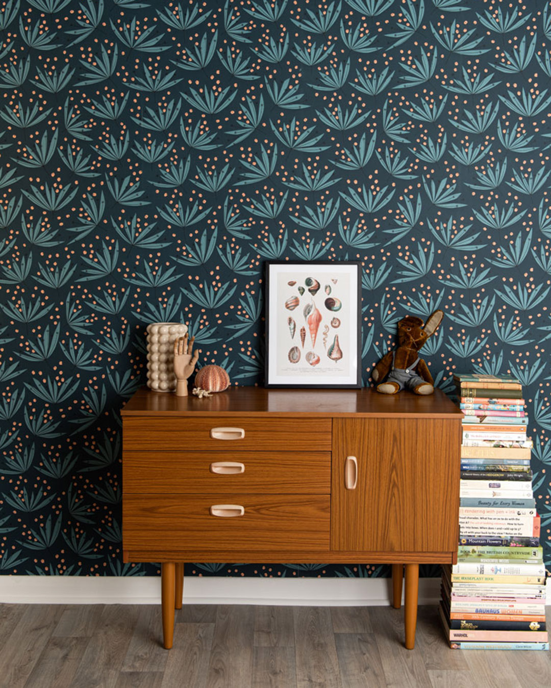 mörk blommig retrotapet barnrum med en byrå teakmöbel och retro interiör